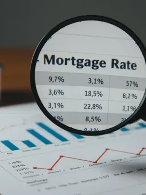 Hand analyzing 2026 mortgage rates on a financial document with housing market trends.